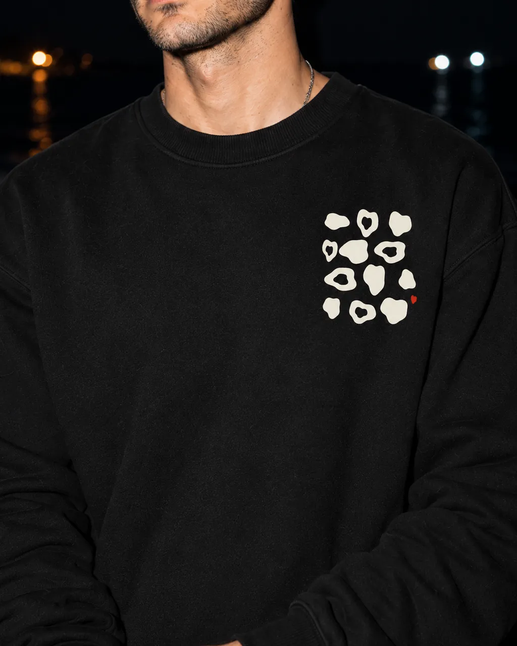 Çakıltaşı Premium Siyah Sweatshirt: göğüsteki baskı yakından, gece siyah çakıllı bir sahilde