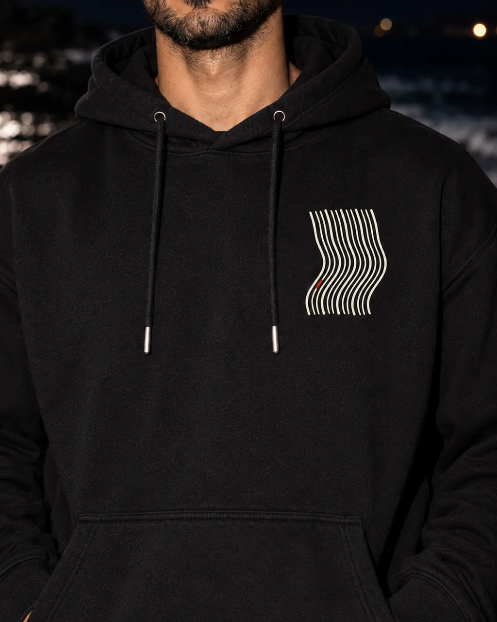 Kavis Premium Siyah Hoodie: göğüsteki baskı yakından, gece dalga çizgisinde