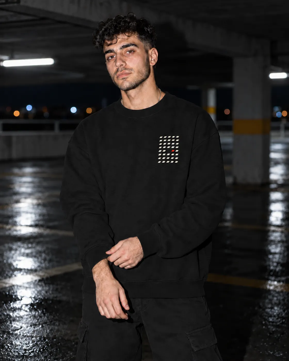 Aralık Premium Siyah Sweatshirt: model üzerinde, gece boş bir otoparkta